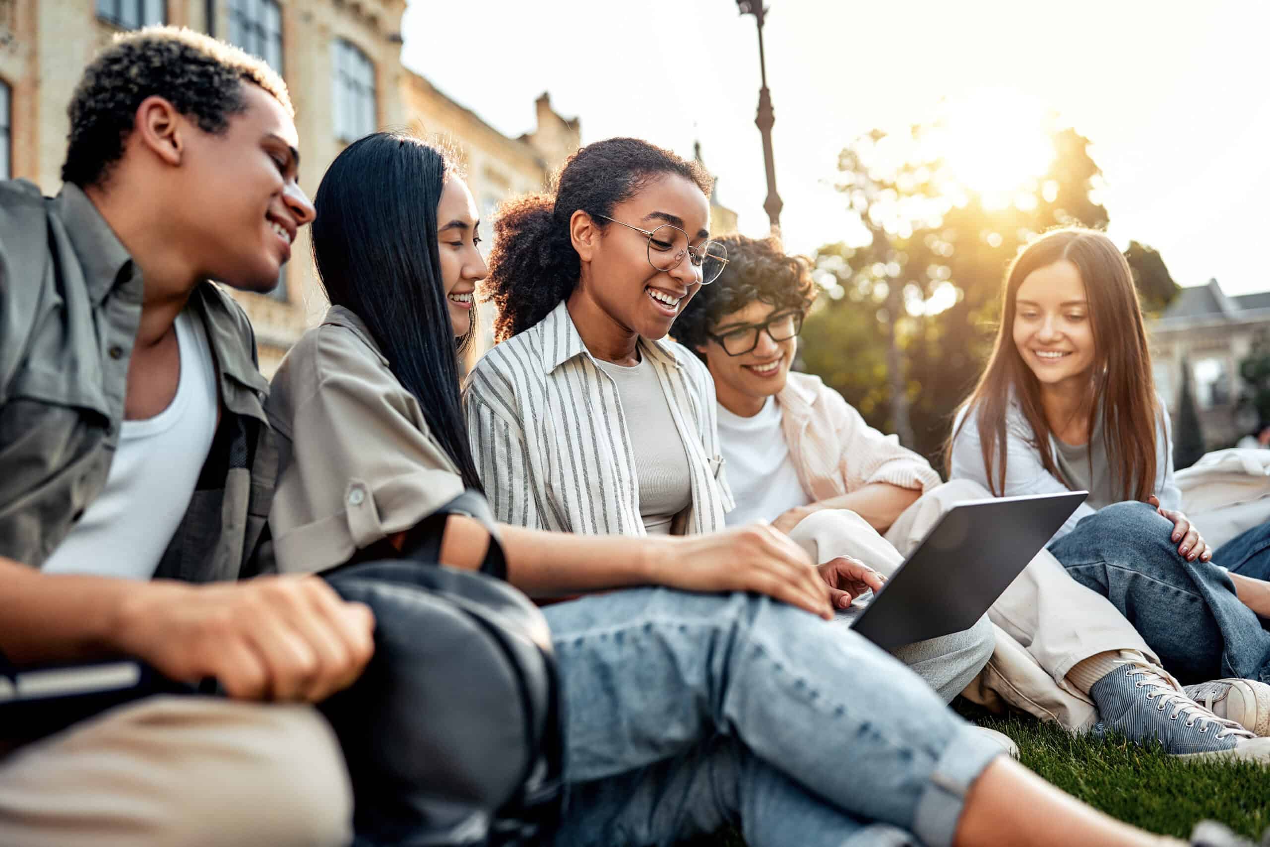 People smiling and looking at a laptop