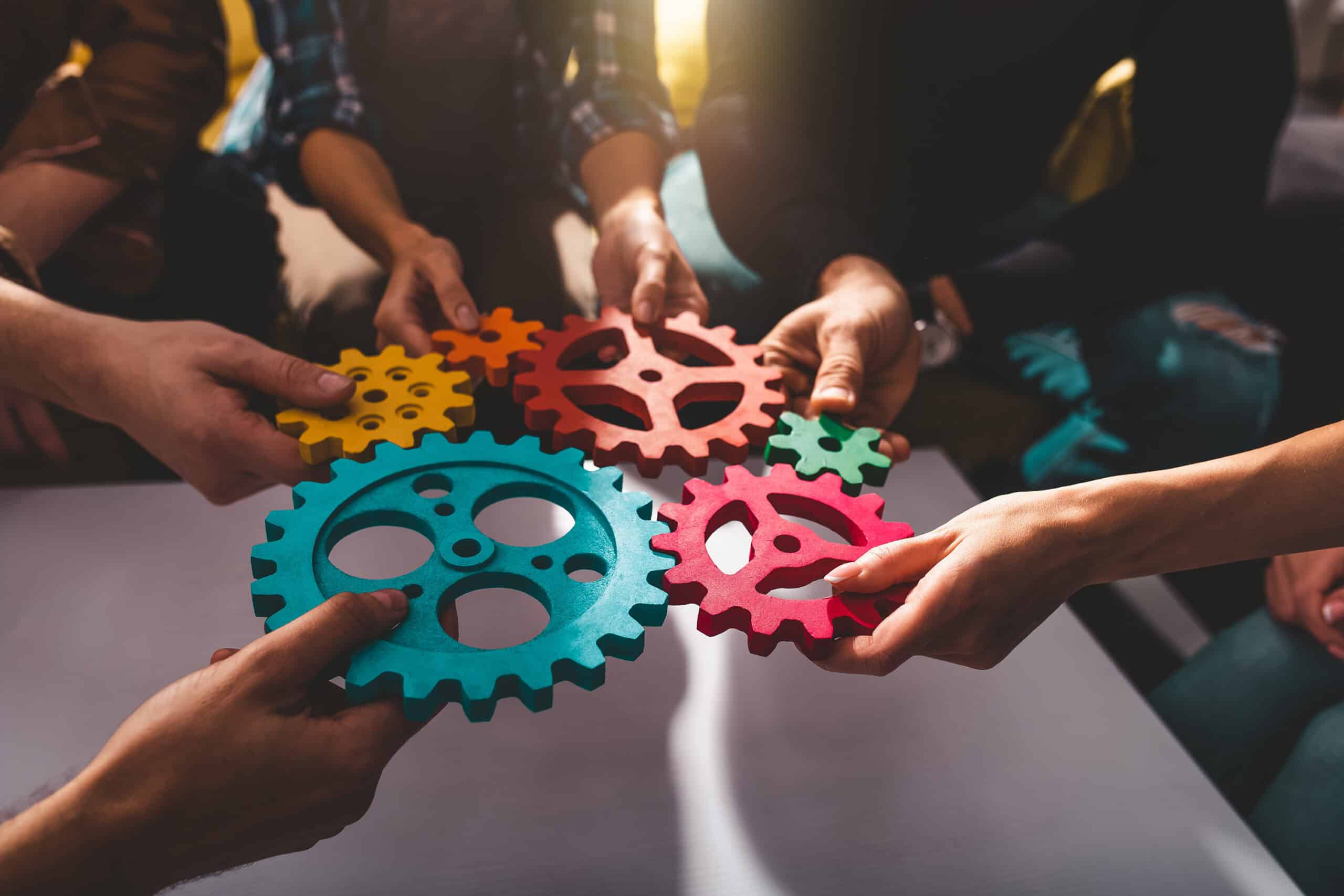 Group of people putting gears together in a circle