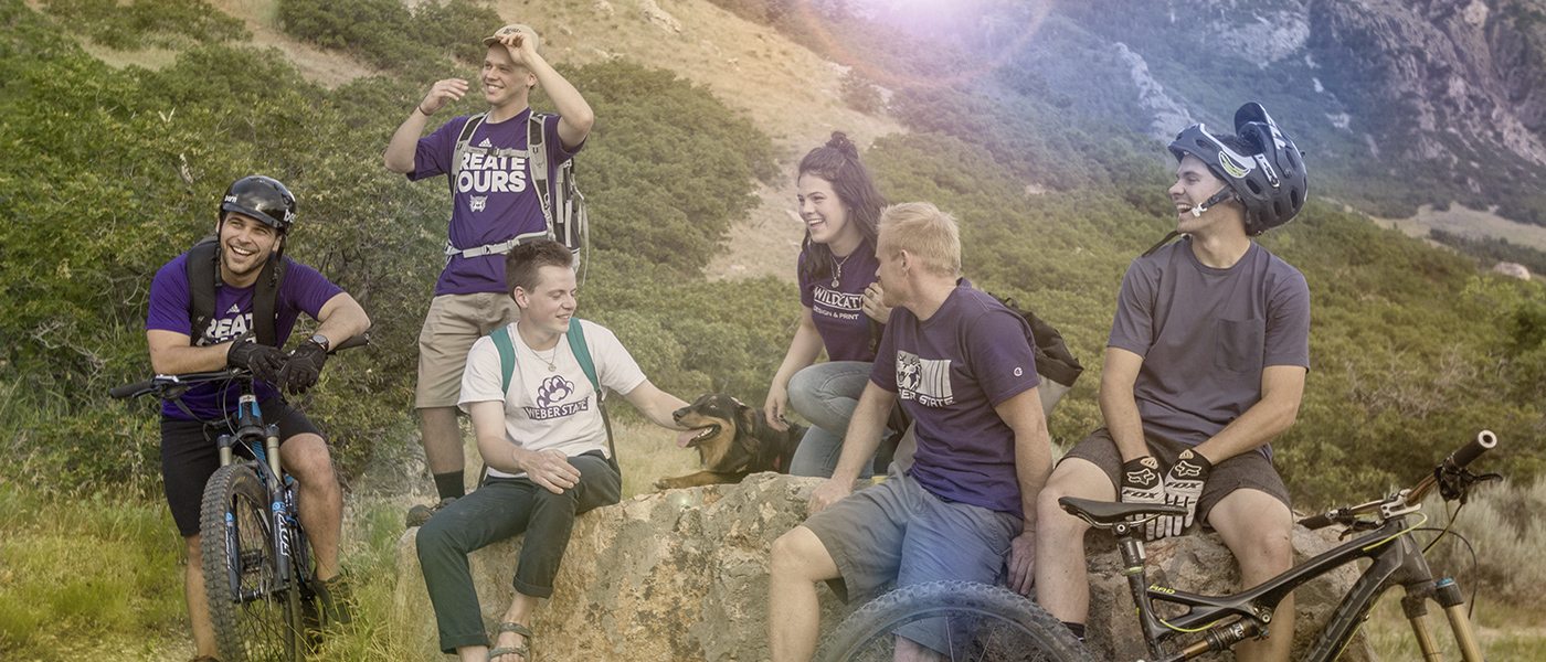 Six college students resting while on a mountain trail hike