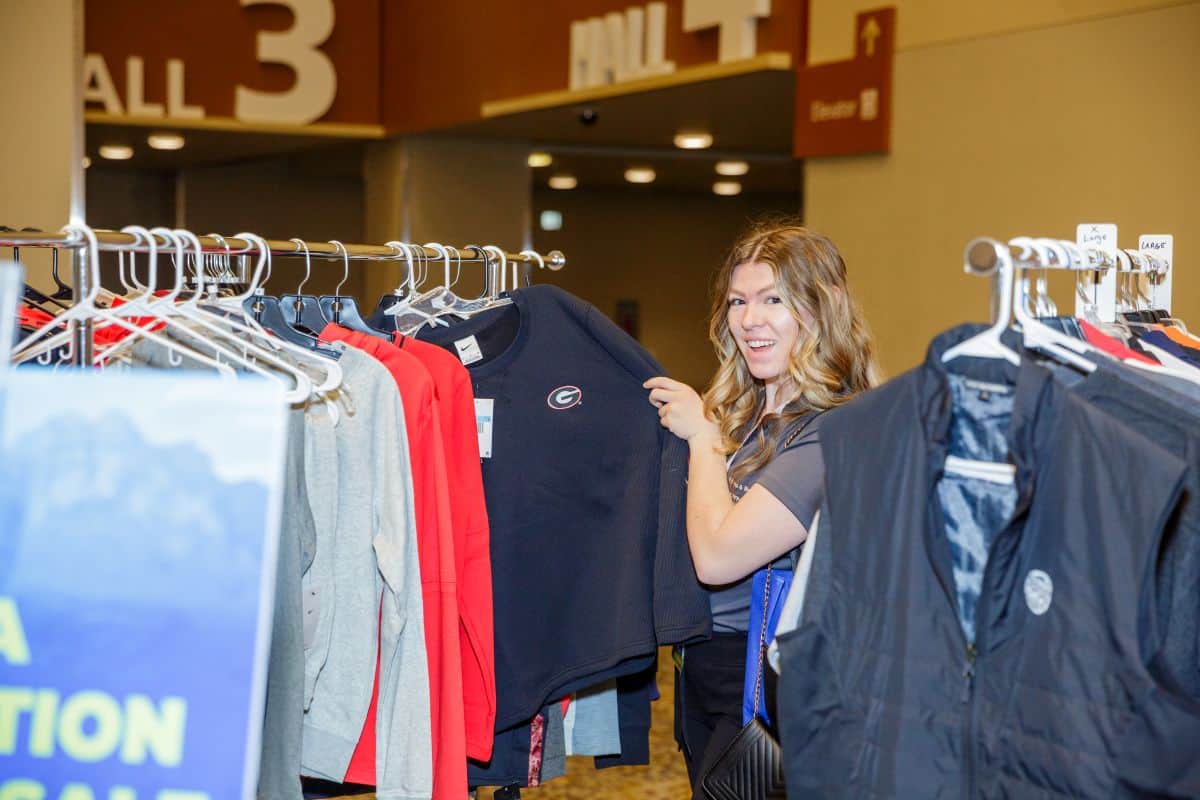Person looks through clothing racks at the NIRSA Foundation Premium Swag Pop-Up Shop