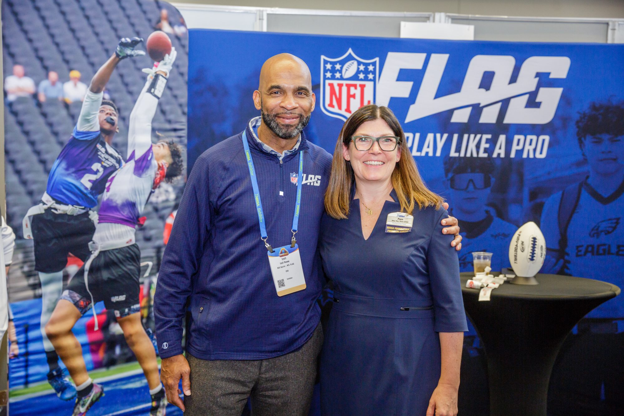 Two people standing in front of NFL Flag booth